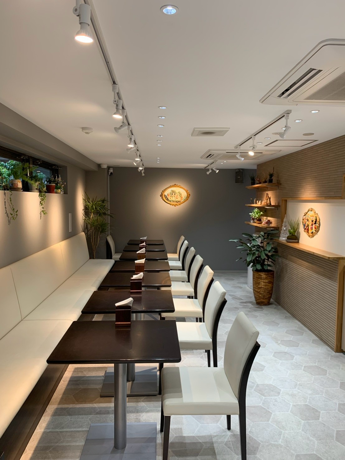 白いベンチとテーブルが並ぶL’escaleの店内全景